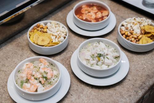 a group of bowls of food on a counter at Hilton Colon Guayaquil Hotel in Guayaquil