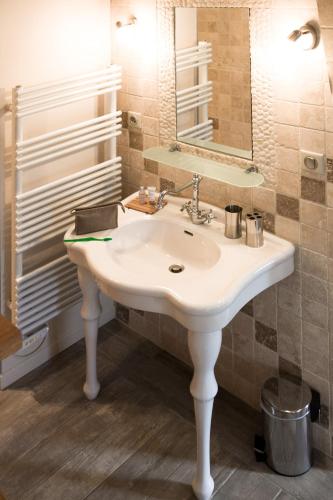 a bathroom with a white sink and a mirror at Château Latour Segur Suites & Spa in Lussac