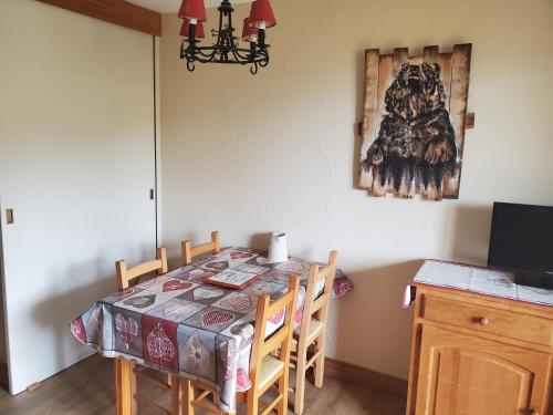 une table à manger avec des chaises et une photo sur le mur dans l'établissement Chouette appartement au pied des pistes (4 max), à Les Deux Alpes