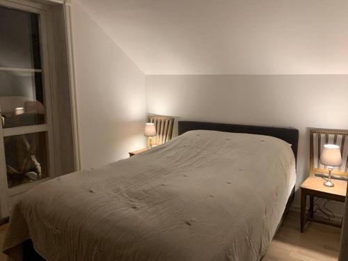 a bedroom with a bed and two tables with lamps at 1800 tals Sjötorp med egen strand och brygga in Åkersberga