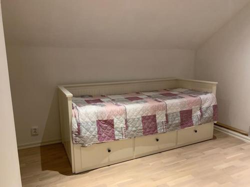 uma cama num quarto com uma cama no canto em 1800 tals Sjötorp med egen strand och brygga em Akersberga