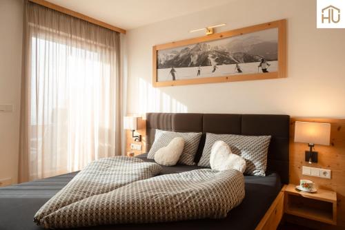 a bedroom with a bed and a large window at Haus Percha Mountain Apartments in Perca