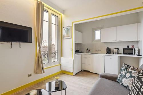 ein Wohnzimmer mit einem Sofa und einer Küche in der Unterkunft Unique Apartment for 4 - Paris & Disney in Champigny-sur-Marne