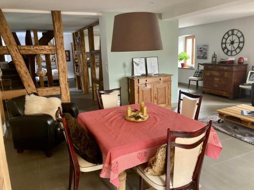 une salle à manger avec une table et des chaises rouges dans l'établissement Cocon à colombage alsacien "1789", à Innenheim