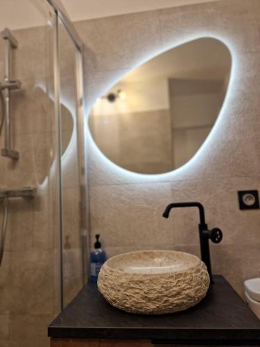 une salle de bain avec un lavabo en pierre et un miroir dans l'établissement Léman Holidays - Le Palm, à Mandelieu-la-Napoule