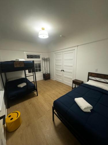 a bedroom with a bed and a bunk bed with a yellow stool at USC University Koreatown Olympic Pico in Los Angeles