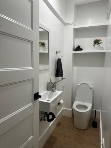 a white bathroom with a toilet and a sink at USC University Koreatown Olympic Pico in Los Angeles