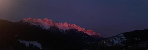 Una montaña con una luz roja por la noche en Da Nicola e Laura, en Santo Stefano di Cadore