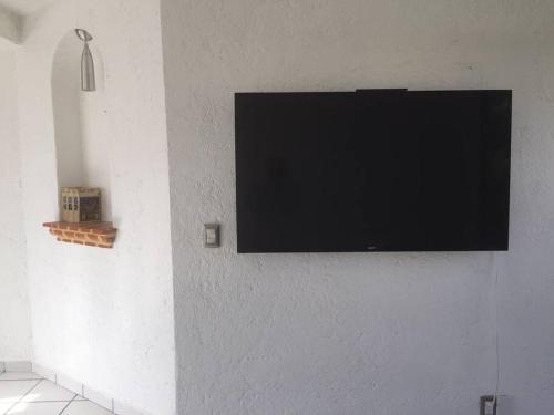 a flat screen tv hanging on a wall at Lomas de Cocoyoc , Family- Friendly in Cocoyoc