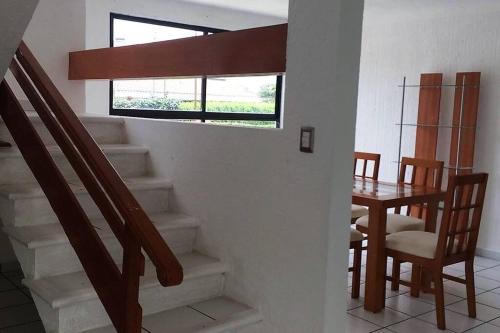 a room with a staircase and a table and a window at Lomas de Cocoyoc , Family- Friendly in Cocoyoc