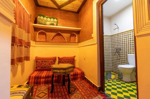 a small bathroom with a bed and a toilet at Kasbah Assafar in El Kelaa des Mgouna