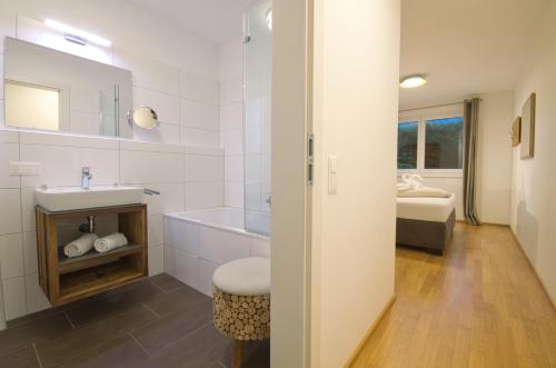 y baño con bañera, lavabo y aseo. en Golf & Glacier View - by Alpen Apartments en Zell am See