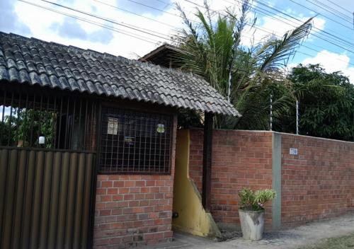 a brick house with a wall and a fence at Casa 04 do Condomínio Privê Portal das Flores in Gravatá