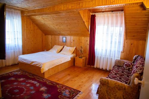 um quarto com uma cama e uma cadeira num quarto em Casa Pop em Câmpulung