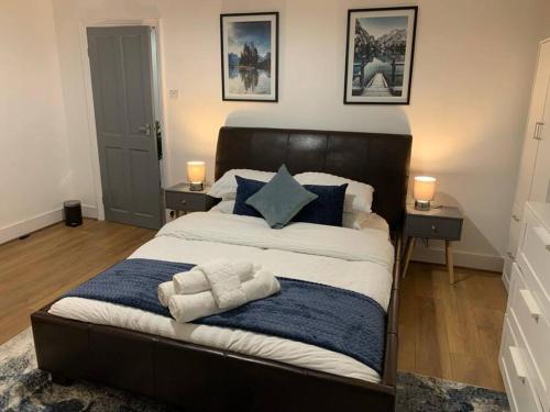 um quarto com uma cama grande e almofadas azuis em Cosy Apartment in London em Londres