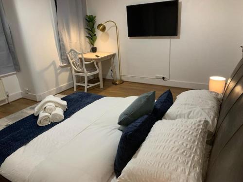 um quarto com uma cama grande e uma televisão na parede em Cosy Apartment in London em Londres