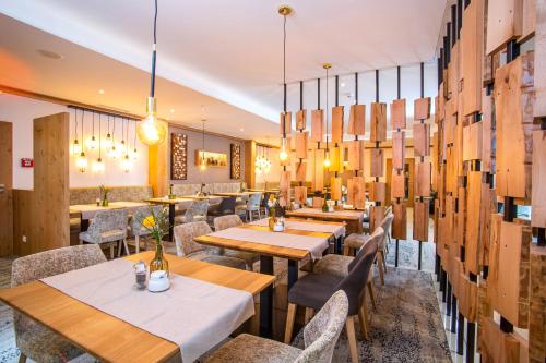 a restaurant with wooden tables and chairs and lights at Hotel Konradshof in Bad Griesbach