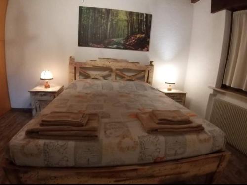 - une chambre avec un grand lit et 2 tables de chevet dans l'établissement Mansarda Natalia, à Gallio