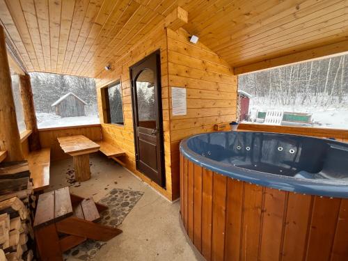 una gran bañera azul en una cabaña de madera en Domek na Stasince, en Sidzina