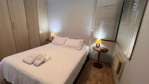 ein kleines Schlafzimmer mit einem Bett mit zwei Handtüchern darauf in der Unterkunft Flat Saint Charles in Jundiaí