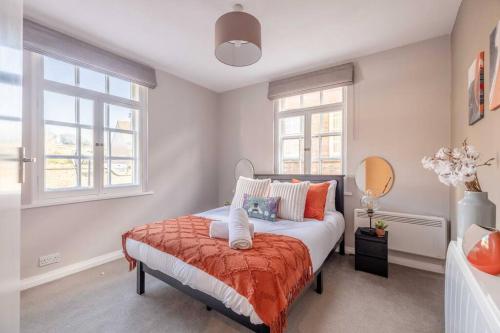 a bedroom with a bed and two windows at Windsor Castle Chic: 1BR,Parking in Windsor