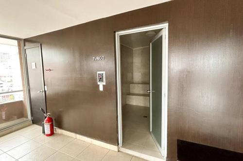 a bathroom with a walk in shower with a fire extinguisher at Departamento con vista panorámica in Quito