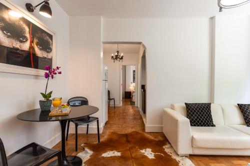 uma sala de estar com um sofá branco e uma mesa em Unhotel - Apartamento Design no Leblon, Perto da Praia no Rio de Janeiro