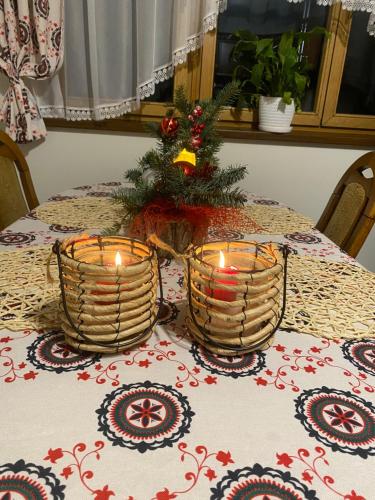 twee kaarsen op een tafel met een kerstboom bij Dom Tatrzański Widok in Bustryk