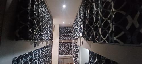 a hallway with black and white patterned walls at New Passenger Dormitory in Mumbai