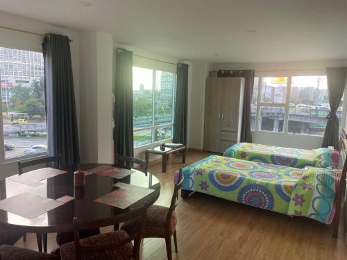 ein Schlafzimmer mit einem Bett und einem Tisch sowie ein Esszimmer in der Unterkunft Sweet Flat in Bogotá