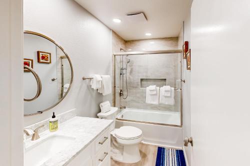 La salle de bains est pourvue d'un lavabo, de toilettes et d'une douche. dans l'établissement Sunny Vistas Bungalow, à Oceanside