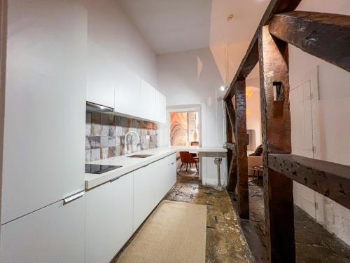 uma cozinha com armários brancos e uma sala de jantar em Fullest Apartments em Lisboa