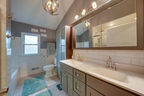 a bathroom with a sink and a toilet and a mirror at Cozy Lisle Home with Fenced Backyard Pets Welcome! in Lisle