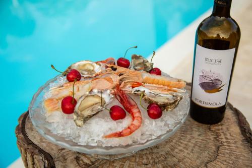 a plate of food with seafood and a bottle of wine at Green Oasis Gabella in Castelforte