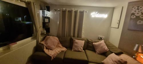 a living room with a couch with pillows on it at Shoreline Stays, Family Caravan, Withernsea, Newly Managed in Waxholme