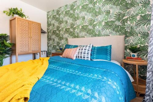 a bedroom with a blue bed with a yellow blanket at Casita Amarilla, Tiny House in San Diego