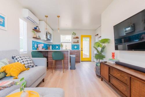 sala de estar con sofá y TV en Casita Amarilla, Tiny House, en San Diego