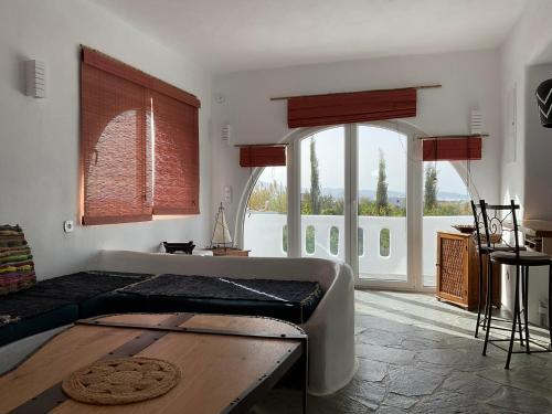 a living room with a bed and a large window at Villa Xanthos in Plaka