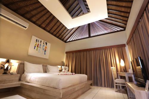 a bedroom with a bed and a tv in a room at Living Asia Resort and Spa in Senggigi