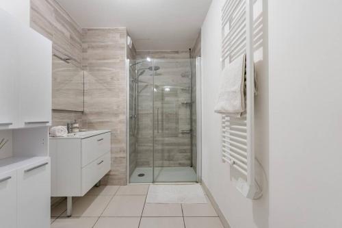 une salle de bain blanche avec une douche et un lavabo dans l'établissement La compagnie du midi/centre ville (gare)/T3/parking/wifi, à Bordeaux