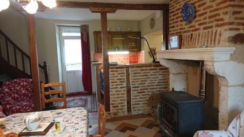 a living room with a fireplace and a stove at Le Gîte du Hérisson, Gîte de charme et de confort in Le Menoux
