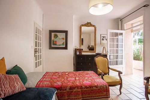 a bedroom with a bed and a dresser and a mirror at La Maison et son jardin clos in Porquerolles