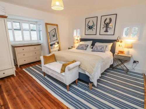 ein Schlafzimmer mit einem großen Bett und einem Stuhl in der Unterkunft Palm Tree Cottage in Sandown