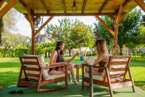 two women sitting at a table under a gazebo at Green Oasis Gabella in Castelforte