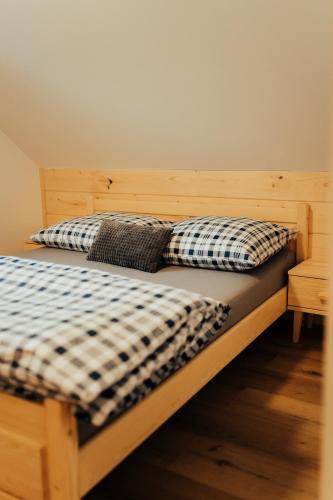 a wooden bed with two pillows on it at Chata pod Mníchom in Terchová