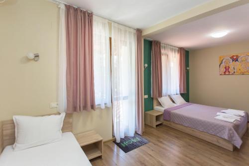 Habitación de hotel con 2 camas y ventana en Къща за гости Перуника, en Sapareva Banya