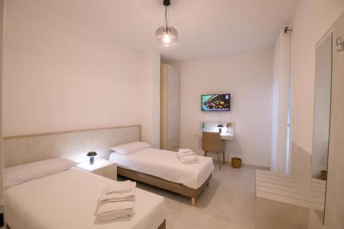 a hotel room with two beds and a table at A Due Passi in Montesano Scalo