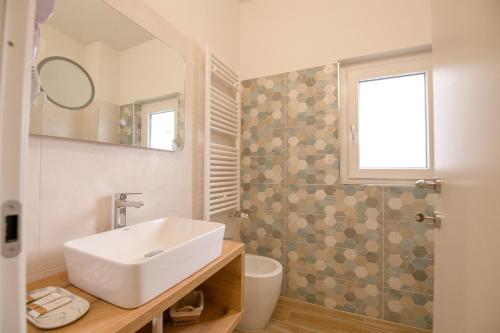 a bathroom with a sink and a toilet and a window at A Due Passi in Montesano Scalo