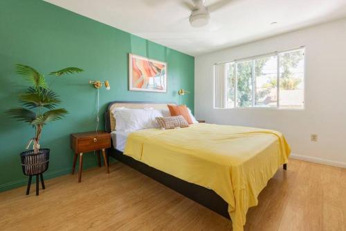 サンディエゴにあるEmerald Guest Houseの緑の壁、ベッド付きのベッドルーム1室