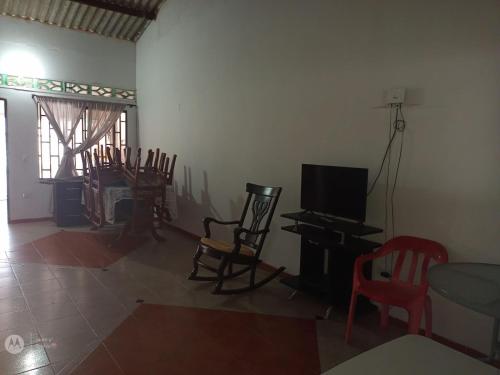 - un salon avec des chaises, une télévision et une table dans l'établissement Casa Ana, à Santiago